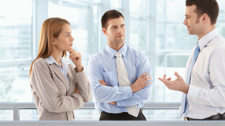 3 profissionais em pé conversando