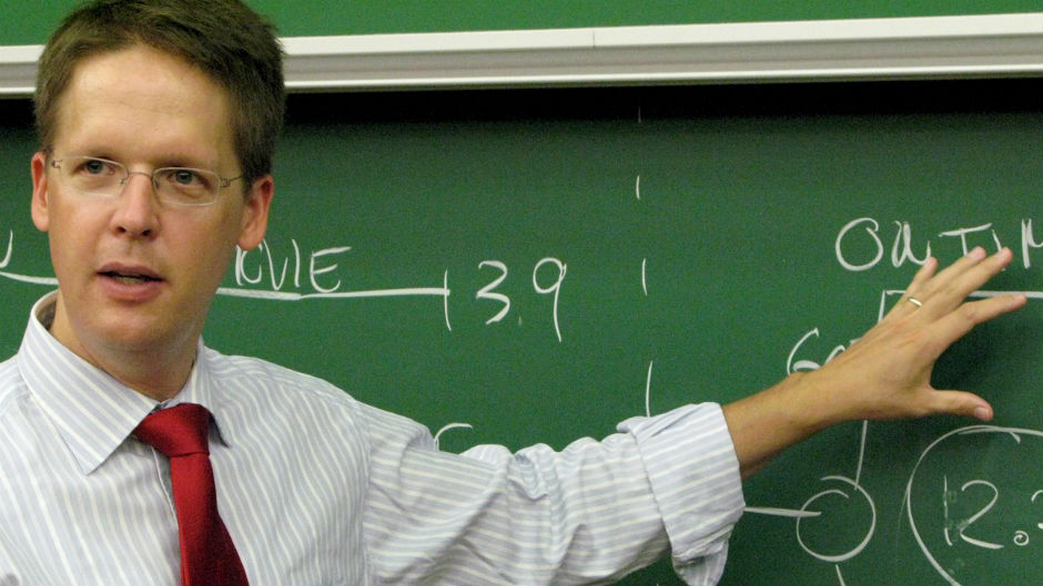 professor explicando em frente à lousa