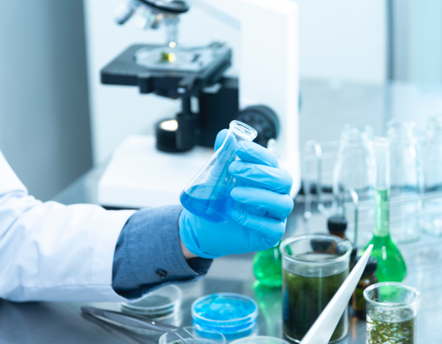 Em laboratóio de Biologia, uma pessoa manuseia ferramentas científicas